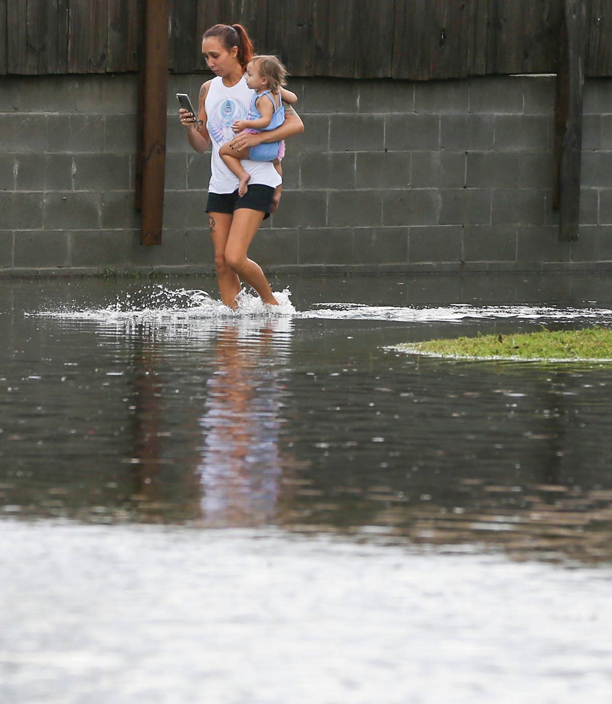 A woman walks through a flooded parking lot in August after a strong late afternoon thunderstorm dumped a torrent of rain on Fort Walton Beach.