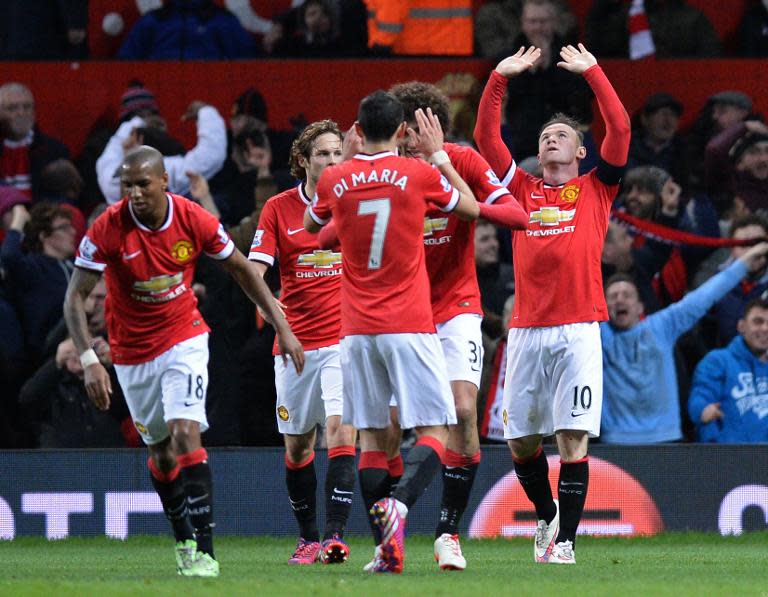 Manchester United's striker Wayne Rooney (R) celebrates scoring their first goal with teammates during the FA Cup quarter-final football match between Manchester United and Arsenal at Old Trafford on March 9, 2015