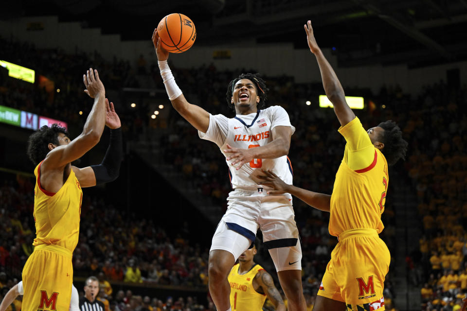 Illinois guard Terrence Shannon Jr. (0) goes to the basket for a layup against two Maryland defenders during the first half of an NCAA college basketball game, Friday, Dec. 2, 2022, in College Park, Md. (AP Photo/Terrance Williams)