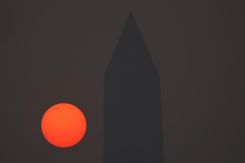 The sun rises behind the Washington Monument and a thick layer of smoke, Thursday, June 8, 2023, in Washington. Intense Canadian wildfires are blanketing the northeastern U.S. in a dystopian haze, turning the air acrid, the sky yellowish gray and prompting warnings for vulnerable populations to stay inside. (AP Photo/Julio Cortez)