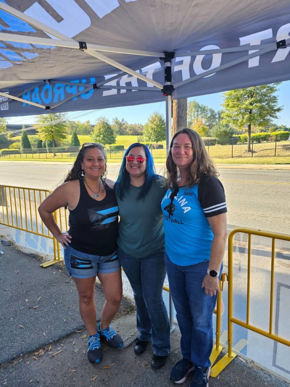 Erika Moulton, left, and friends pose for a photo at a Roaring Riot tailgate before a Carolina Panthers game. Moulton wears clothing with a flag stitched on — one that merges the design of the Puerto Rican flag with the colors and logo of the Panthers team logo: “I wear my Hispanic pride at every game,” she said. Courtesy of Erika Moulton
