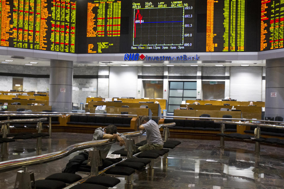 Investors sit at private stock trading boards at a private stock market gallery in Kuala Lumpur, Malaysia, Tuesday, Oct. 16, 2018. Asian markets were mostly higher on Tuesday, though Chinese benchmarks fell after the government reported inflation rose for the fourth straight month. (AP Photo/Yam G-Jun)