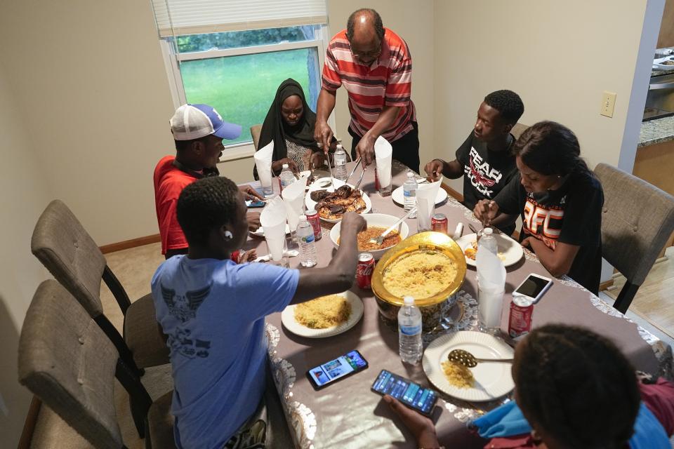 Mauritanians gather for a traditional meal, Friday, July 21, 2023, in Cincinnati. A new surge in migration from Mauritania to the U.S. was made possible by the discovery this year of a new route through Nicaragua, where relaxed entry requirements allow Mauritanians and a handful of other foreign nationals to purchase a low-cost visa without proof of onward travel. (AP Photo/Darron Cummings)