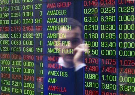 An office worker talks on his phone as he looks the stock board at the Australian Securities Exchange (ASX) building in central Sydney June 15, 2012. REUTERS/Daniel Munoz