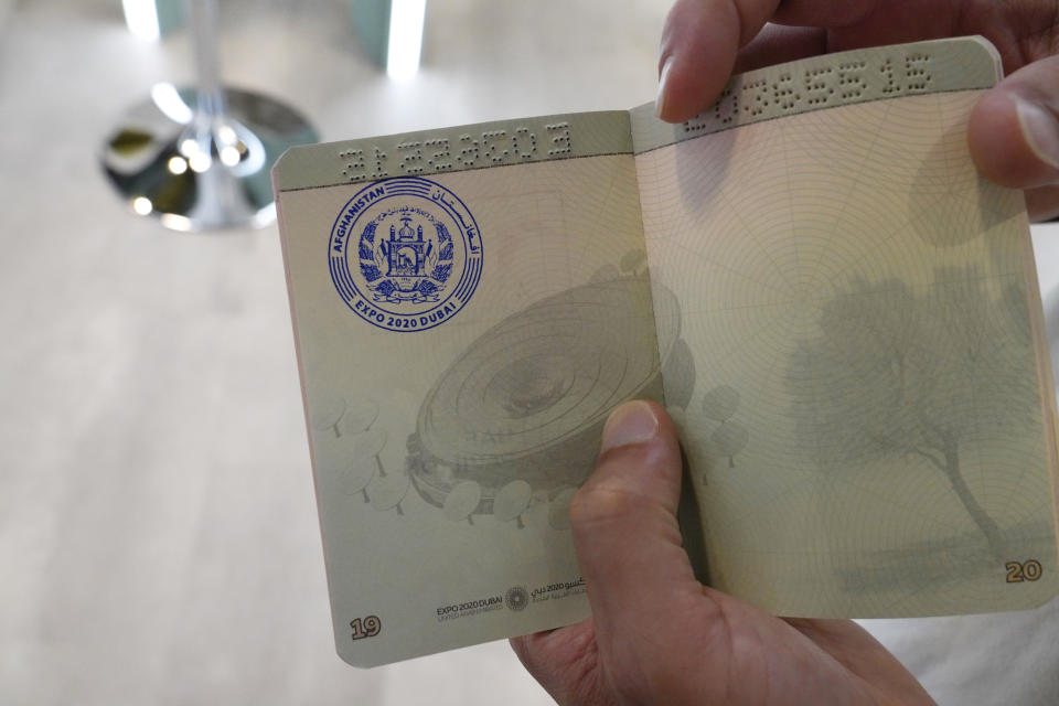 A tourist shows off his Afghanistan stamp in a commemorative passport at Expo 2020 in Dubai, United Arab Emirates, Thursday, Oct. 7, 2021. A Vienna-based antique dealer has opened the Afghanistan pavilion at Expo 2020 about a week after the world's fair began without it amid the turmoil facing his country following the Taliban takeover there. (AP Photo/Jon Gambrell)