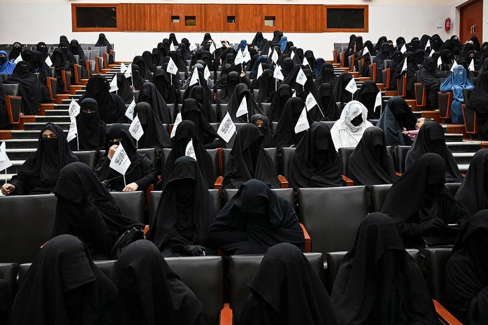 Veiled students hold Taliban flags as they listen a speaker before a pro-Taliban rally at the Shaheed Rabbani Education University in Kabul on September 11, 2021.