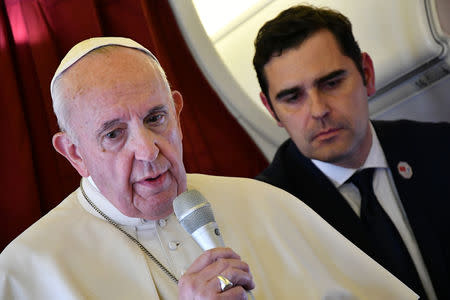 Pope Francis addresses reporters aboard the plane bringing him back following a two-day trip to Morocco, as interim director of the Holy See Press Office, Alessandro Gisotti looks on March 31, 2019. Alberto Pizzoli/Pool via REUTERS