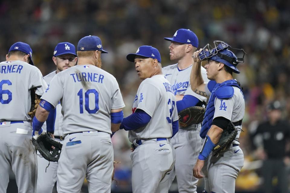 Dodgers manager Dave Roberts meets with players on the mound.