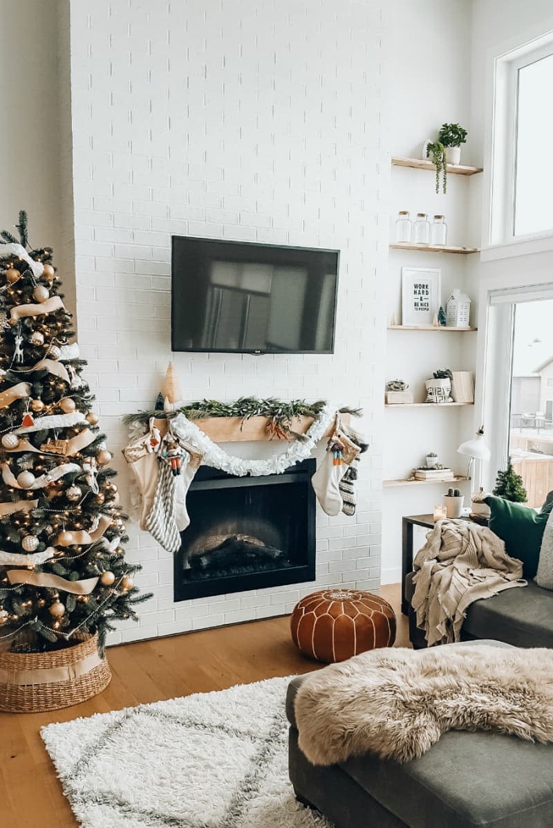 Fireplace mantel decorated with winter greenery and white felt garland