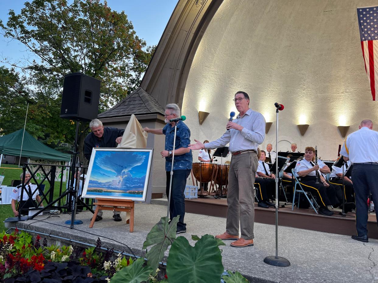 Tim Spransy (center) unveils his painting of Rockwell Park looking out over Lac La Belle to help fundraise for building the park.