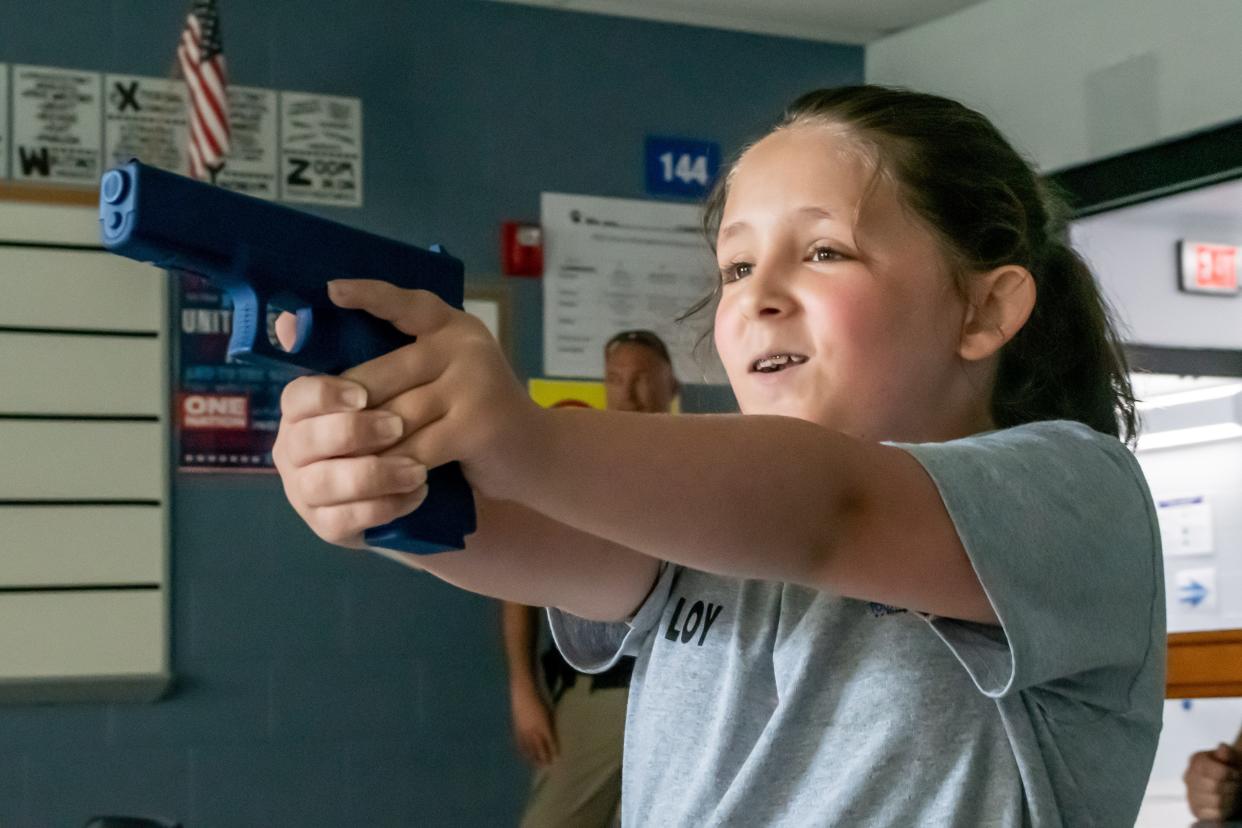 Jazlynne Loy yells at a school intruder with a prop gun during the SWAT team demonstration. Students were taught what to do during an active shooter drill and had the chance to learn how the first responders handle situations during the Cambridge Youth Citizens Police Academy.