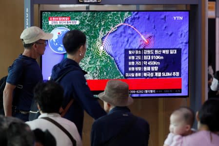 People watch a TV broadcasting a news report on North Korea firing a missile that is believed to be launched from a submarine, in Seoul