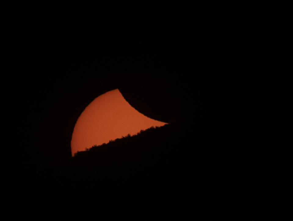 A partially eclipsed sun sets behind a mountain ridge as seen from El Molle, Chile, on July 2, 2019 after the total solar eclipse. (Photo: Stan Honda/AFP/Getty Images)