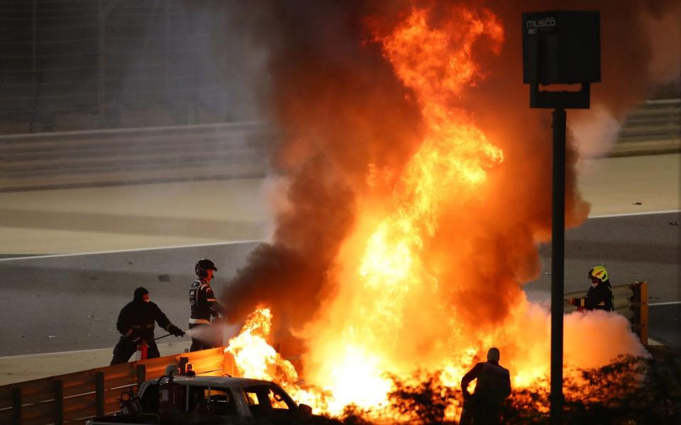 Fire marshals put out a fire on Haas F1's French driver Romain Grosjean's car during the Bahrain Formula One Grand Prix at the Bahrain International Circuit in the city of Sakhir on November 29, 2020 - AFP /BRYN LENNON 