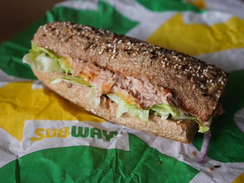 A "Tuna Sandwich" from the fast food chain "Subway" lies on a table.