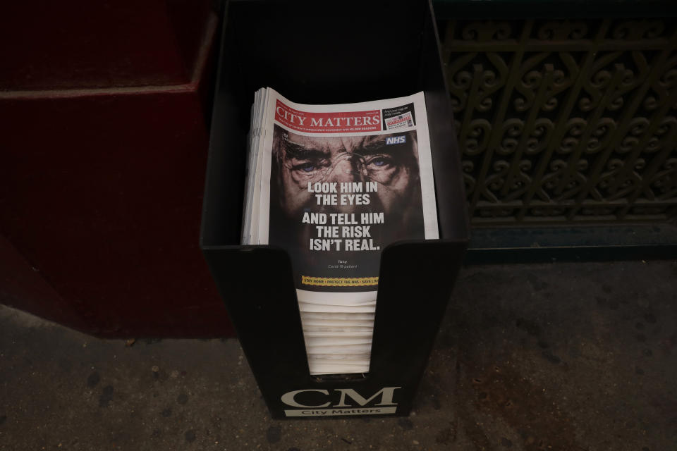 FILE - In this Tuesday, Feb. 23, 2021 file photo a stack of newspapers is displayed for passersby by to take at Leadenhall Market in the City of London financial district of London, during England's third coronavirus lockdown. (AP Photo/Matt Dunham, File)