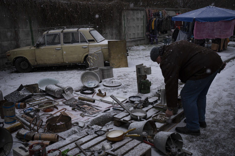 Un hombre ve objetos en un mercado de pulgas en Kiev, Ucrania, el sábado 4 de febrero de 2023. (AP Foto/Daniel Cole)