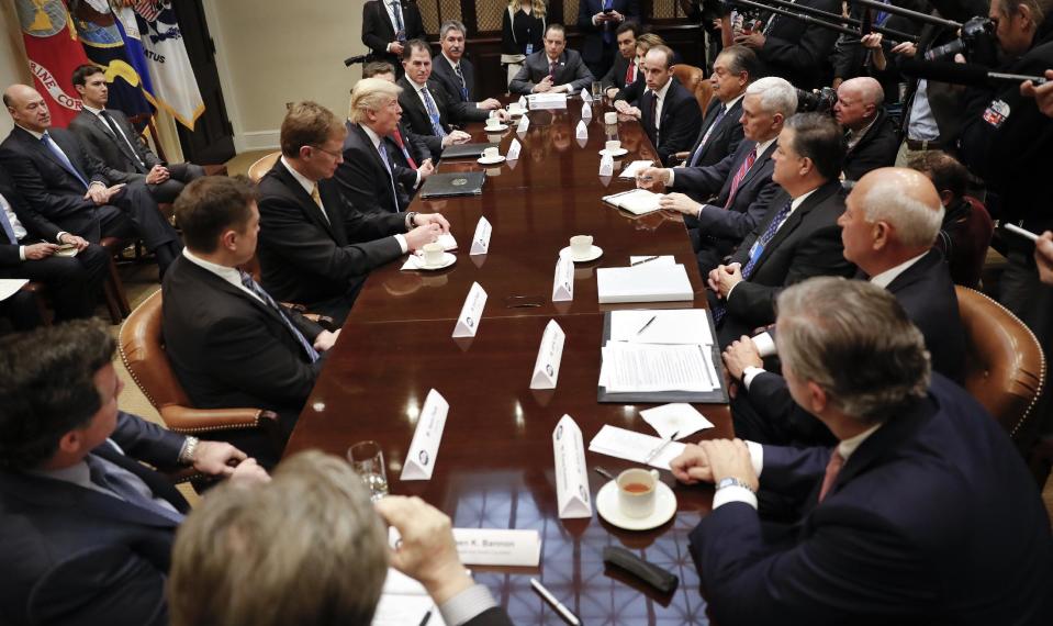 In this photo taken Jan. 23, 2017, President Donald Trump, left center, host a breakfast with business leaders in the Roosevelt Room of the White House in Washington. At the meeting starting from the top going clockwise, White House Chief of Staff Reince Priebus, Mark Fields from Ford Motor Company, Marillyn A. Hewson from Lockhead Martin, White House Policy Adviser Stephen Miller, Andrew Liveris from Dow Chemicals, Vice President Mike Pence, Mark Sutton from International Paper, Jeff Fettig from Whirlpool, Klaus Kleinfeld from Arconic, White House Senior Adviser Steve Bannon, left, Kevin Plank from Under Armour, Elon Musk from Telsa and SpaceX, Wendell P. Weeks from Corning, President Trump, Alex Gorsky from Johnson & Johnson, Michael S. Dell from Dell Technologies and Mario Longhi from US Steel. (AP Photo/Pablo Martinez Monsivais)