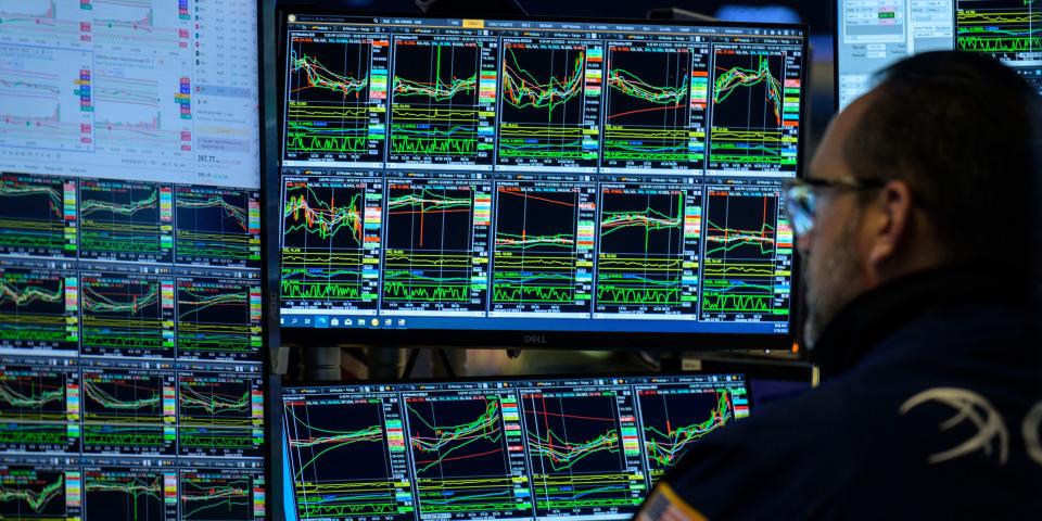 A trader looks at market charts on the floor of the New York Stock Exchange.