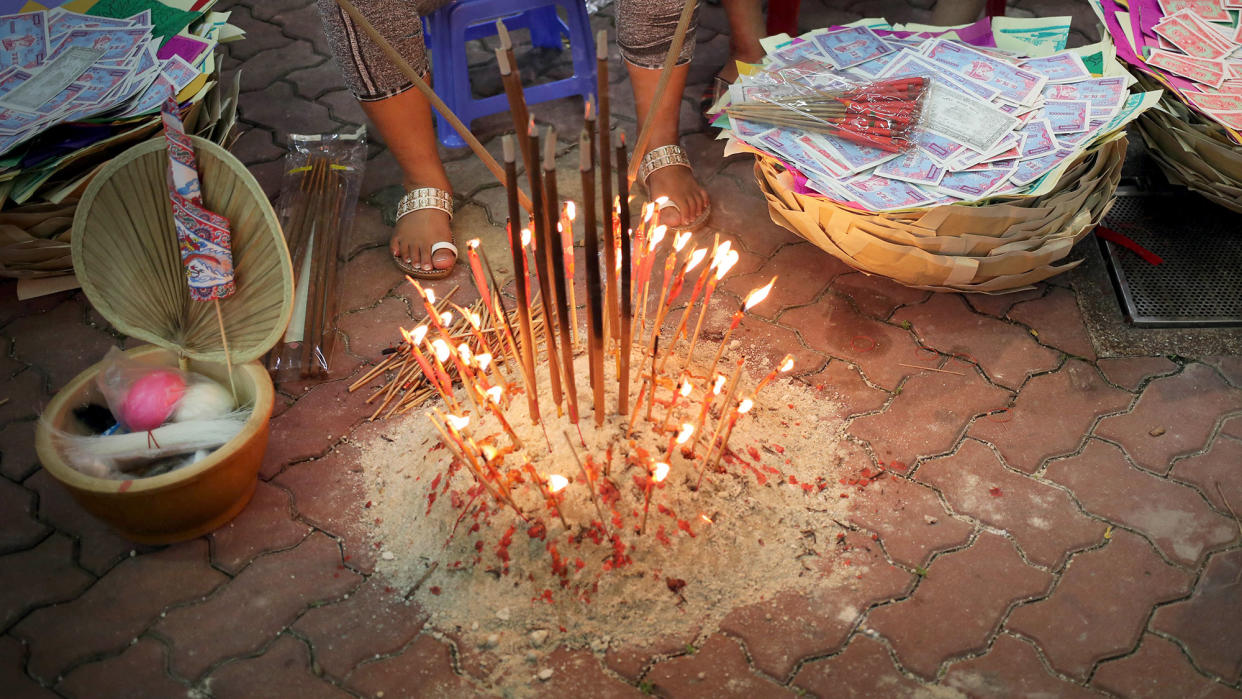 Women burn incense sticks as offerings during the Hungry Ghost Festival celebrated in Singapore. (PHOTO: AP/Wong Maye-E)
