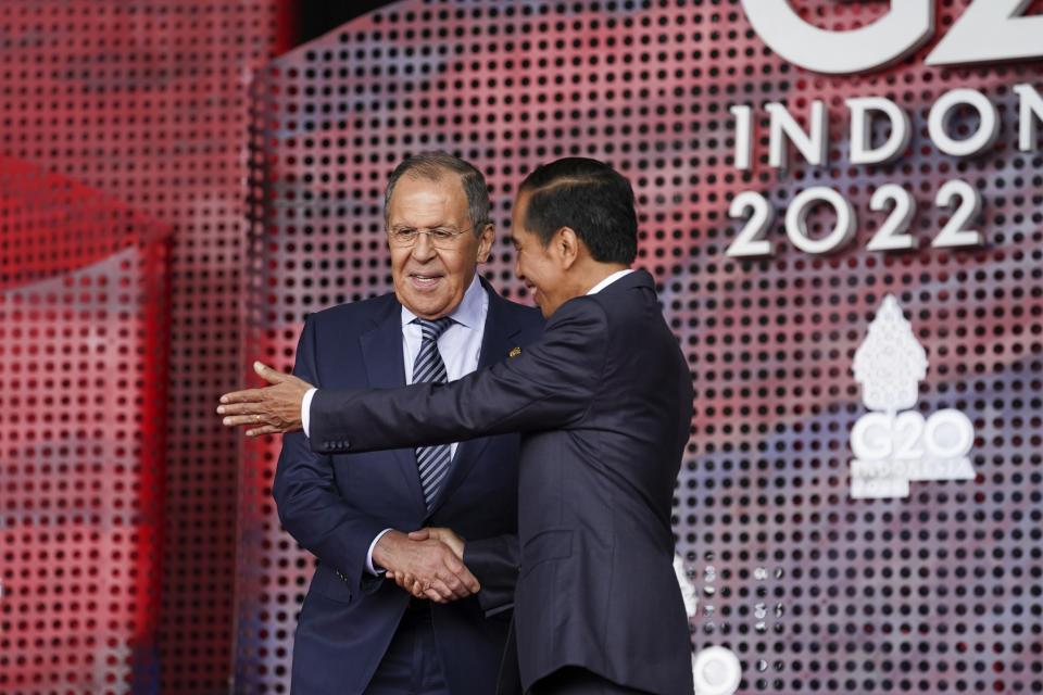 Russian Foreign Minister Sergey Lavrov greets Indonesia's President Joko Widodo as he arrives for the G20 leaders' summit in Nusa Dua, Indonesia, Tuesday, Nov. 15, 2022. (Kevin Lamarque/Pool via AP)