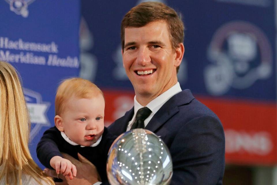 Eli Manning and son Charlie | Adam Hunger/AP/Shutterstock