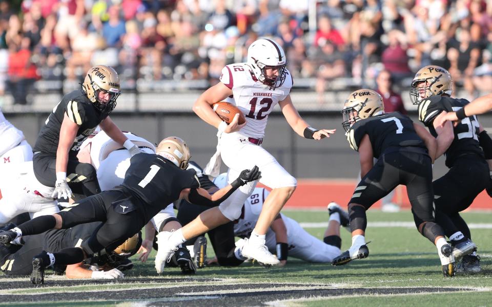 Mishawaka quarterback Brady Fisher (12) breaks out for a touchdown during the game Friday, Aug. 25, 2023, at the Mishawaka vs. Penn football game at Freed Field.