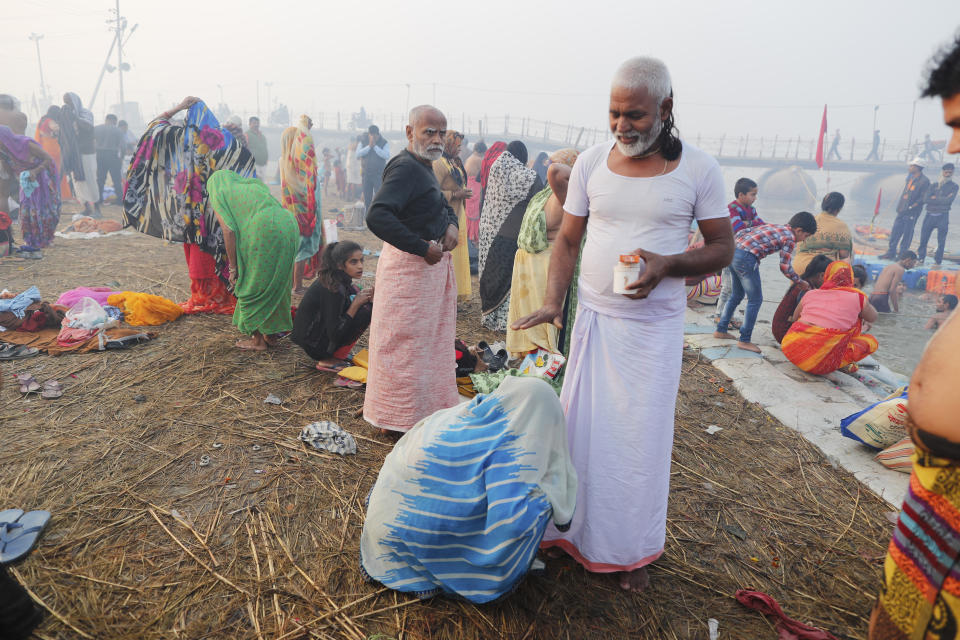 Virender Kumar Shukla, a Kalpvasi or a devotee who chooses to stay for the entire time of the festival, blesses his wife as she touches his feet after a holy dip at the Sangam during Magh mela festival, in Prayagraj, India. Friday, Feb. 19, 2021. Millions of people have joined a 45-day long Hindu bathing festival in this northern Indian city, where devotees take a holy dip at Sangam, the sacred confluence of the rivers Ganga, Yamuna and the mythical Saraswati. Here, they bathe on certain days considered to be auspicious in the belief that they be cleansed of all sins. (AP Photo/Rajesh Kumar Singh)