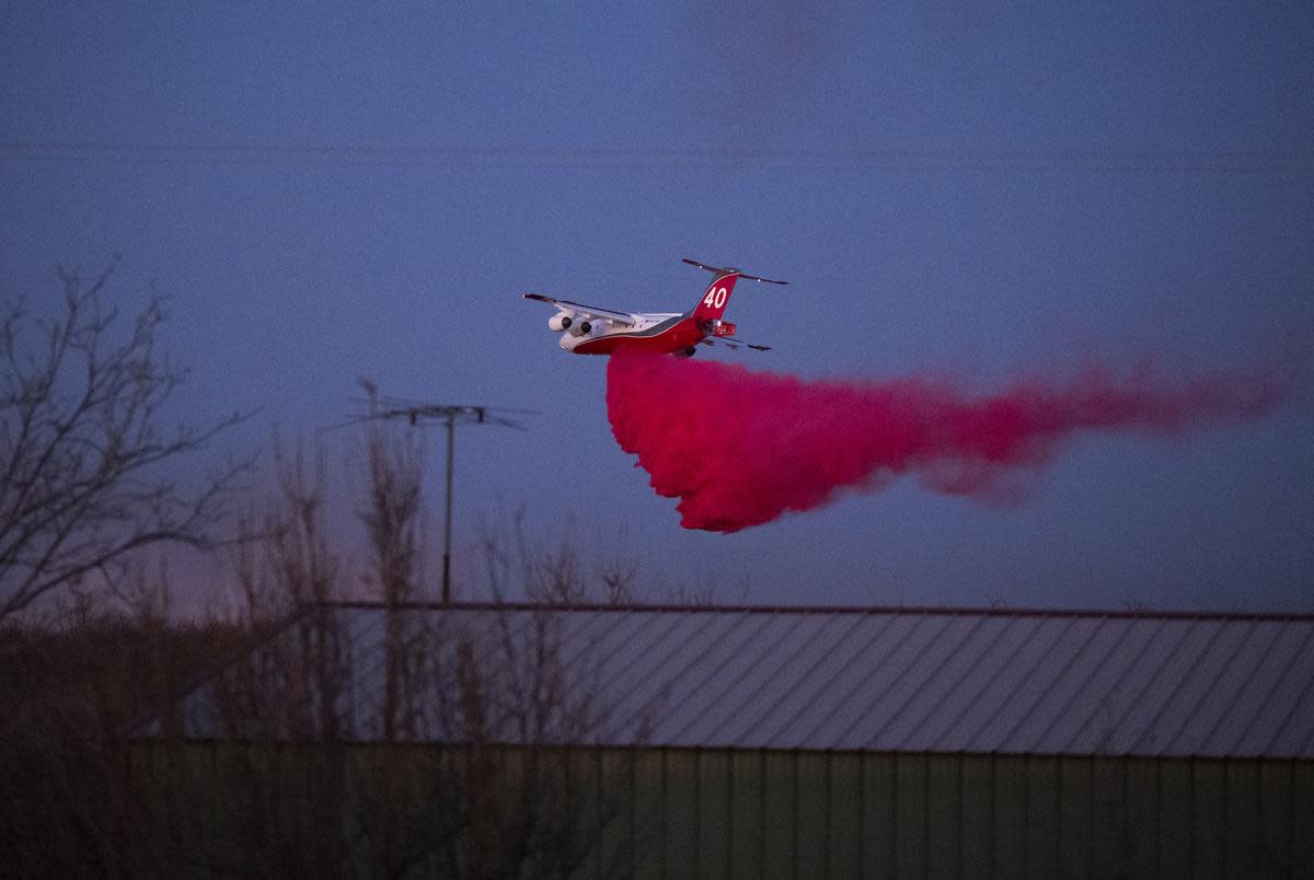 A plane prepares drops retardant on the Roughneck fire near Sanford on Sunday, March. 3, 2024.