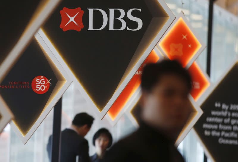 People pass DBS signages at an event in Singapore