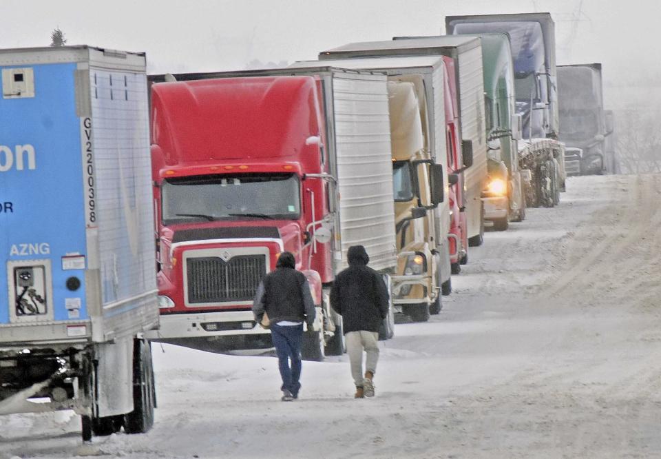 A long line up of over the road trucks lines both sides of Miriam Avenue near the Stamart Travel Center truck stop in east Bismarck, N.D., on Thursday, Dec. 15, 2022. The trucks were waiting for I-94 to reopen after weather and road conditions on Wednesday, Dec. 14, forced closure of the east-west interstate highway. (Tom Stromme/The Bismarck Tribune via AP)