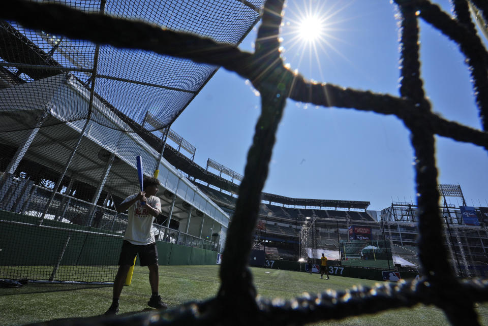 Youths demonstrate a wiffle ball game at the All Star Village set up inside the Choctaw Stadium ahead of the MLB All Star baseball game in Arlington, Texas, Thursday, July 11, 2024. (AP Photo/LM Otero)