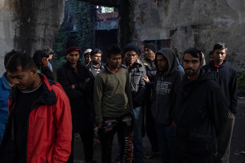 Migrants from Bangladesh stand inside an old abandoned factory near Velika Kladusa