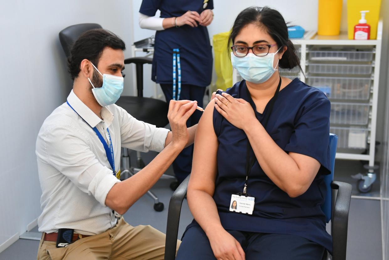 <p>Principal Pharmacist Davinder Manku (right) receives an injection of the Oxford/Astrazeneca coronavirus vaccine at The Black Country Living Museum in Dudley</p> (PA)