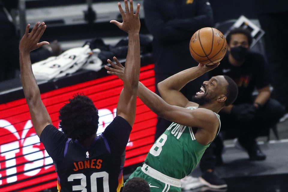 Boston Celtics guard Kemba Walker (8) drives to the basket as Phoenix Suns center Damian Jones (30) defends during the first half of an NBA basketball game, Sunday, Feb. 7, 2021, in Phoenix. (AP Photo/Ralph Freso)