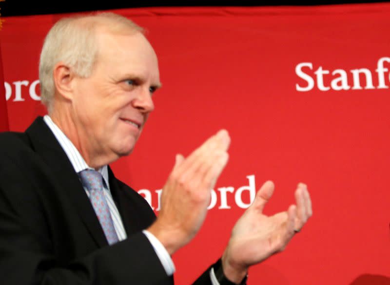 FILE PHOTO - John Hennessy (L), president of Stanford University, applauds during a press conference in Stanford, California