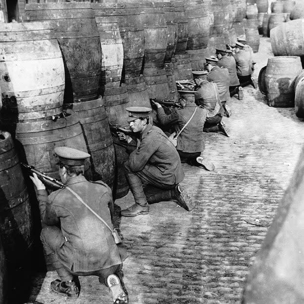 British Regulars sniping from behind a barricade of empty beer casks near the quays in Dublin during the 1916 Easter Rising - Credit: Getty Images