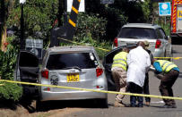 Kenyan policemen and explosives experts gather evidence from the car suspected to have been used by the attackers outside the scene where explosions and gunshots were heard at The DusitD2 complex, in Nairobi, Kenya January 17, 2019. REUTERS/Njeri Mwangi