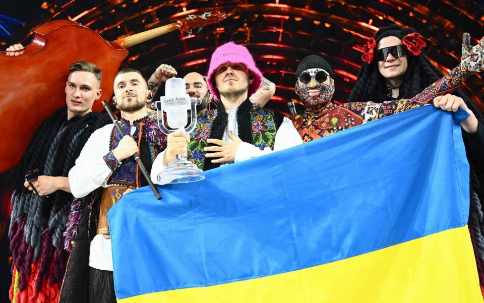 Members of the band "Kalush Orchestra" pose onstage with the winner's trophy and Ukraine's flags after winning on behalf of Ukraine the Eurovision Song contest 2022 on May 14, 2022 at the Pala Alpitour venue in Turin. - Marco Bertorello/AFP