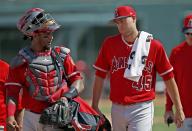 FILE - Los Angeles Angels starting pitcher Tyler Skaggs (45) talks with catcher Martin Maldonado, left, after warming up in the bullpen prior to a spring training baseball game against the Chicago White Sox, March 4, 2017, in Glendale, Ariz. A former Angels employee was convicted Thursday, Feb. 17, 2022, of providing Skaggs the drugs that led to his overdose death in Texas. (AP Photo/Ross D. Franklin, File)