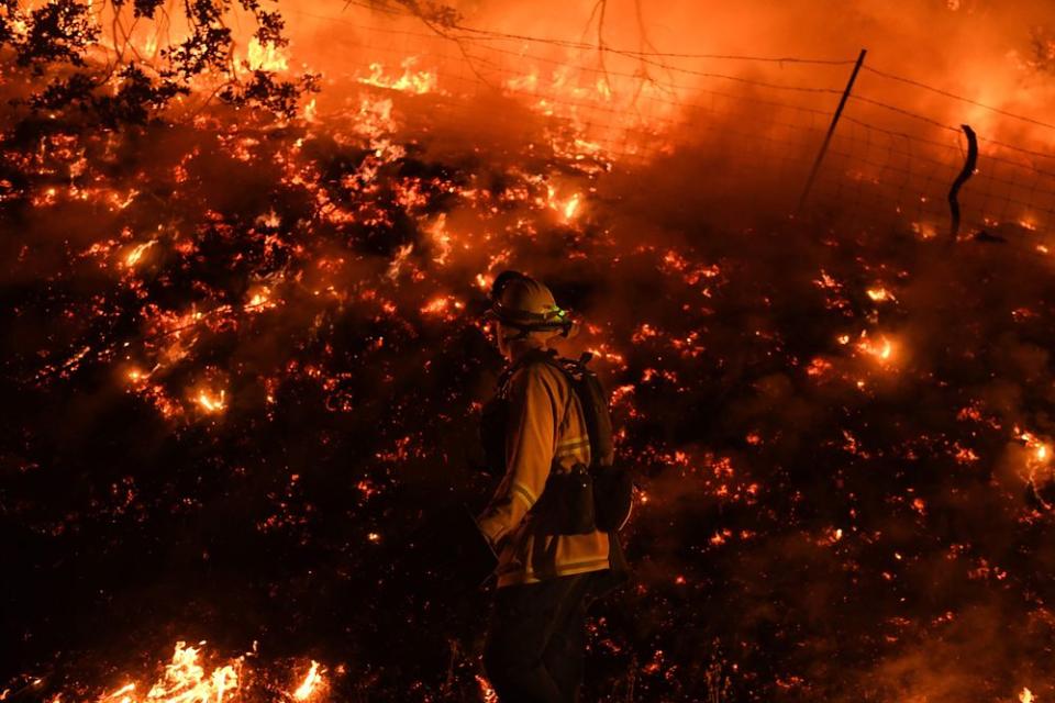 Firefighters conduct a controlled burn to defend houses against flames from the Ranch fire, as it continues to spreads towards the town of Upper Lake, Calif. on Aug. 2.