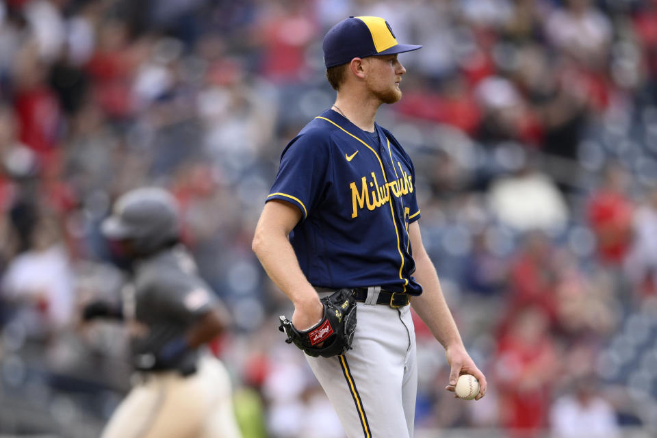 Milwaukee Brewers starting pitcher Eric Lauer, front, looks on as Washington Nationals' Josh Bell, back, rounds the bases after hitting a home run during the fifth inning of a baseball game, Saturday, June 11, 2022, in Washington. (AP Photo/Nick Wass)