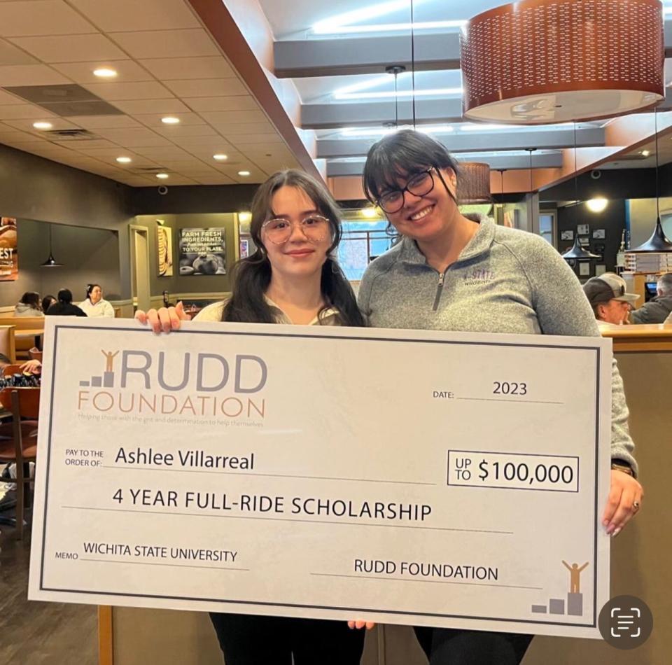 Ashlee Villarreal and Evelyn Irigoyen-Aguirre hold up a check from the Rudd Foundation, showcasing the scholarship that Ashlee plans to use to fund four years of attending Wichita State University, starting this fall.