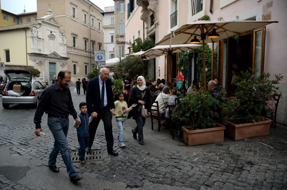 A&nbsp;family of Syrian refugees that Pope Francis brought back with him from the Greek island of Lesbos walks with a Catholic charity worker&nbsp;on April 18, 2016, in Rome. (Photo: FILIPPO MONTEFORTE via Getty Images)