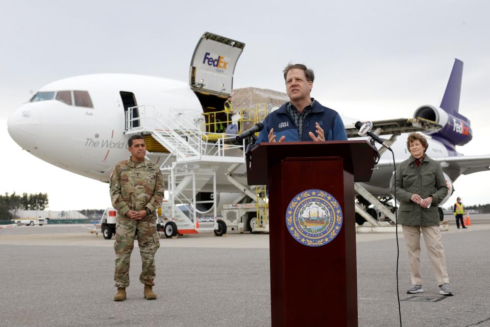New Hampshire Gov. Chris Sununu, center, speaks to reporters, flanked by state National Guard Maj. Gen. David Mikolaities, left, and Sen. Jeanne Shaheen, D-N.H., as pallets containing personal protective equipment are unloaded from a FedEx cargo plane April 12 at Manchester-Boston Regional Airport in New Hampshire.