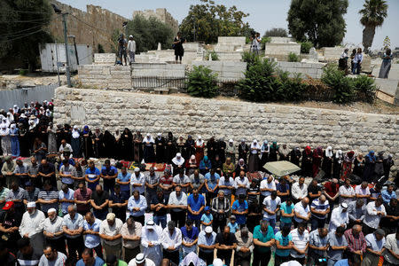 Palestinians pray at Lions' Gate, an entrance to Jerusalem's Old City, in protest over Israel's new security measures at the compound housing al-Aqsa mosque, known to Muslims as Noble Sanctuary and to Jews as Temple Mount July 20, 2017. REUTERS/Ronen Zvulun
