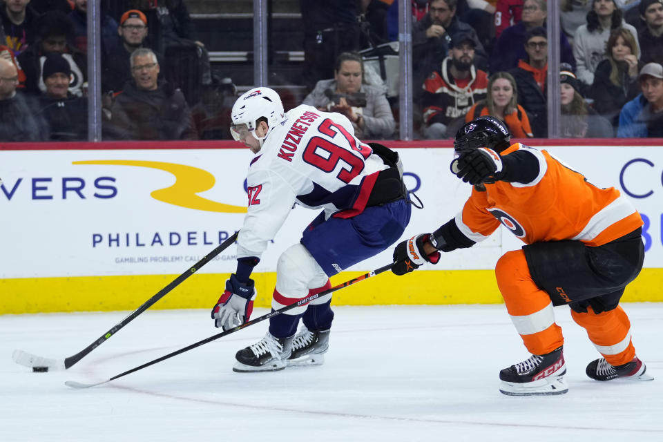 Washington Capitals' Evgeny Kuznetsov, left, tries to get past Philadelphia Flyers' Ivan Provorov during the first period of an NHL hockey game, Wednesday, Jan. 11, 2023, in Philadelphia. (AP Photo/Matt Slocum)