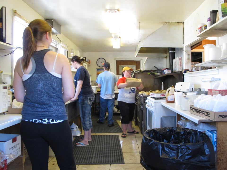 This July 20, 2013 photo shows kitchen workers preparing pasties in Nancy McLaughlin's Pasty Shop in Butte, Mont. The shop is one of a handful that serve the meat-and-potato pie that immigrant miners brought a century ago and has remained a part of Butte's culinary culture. (AP Photo/Matt Volz)