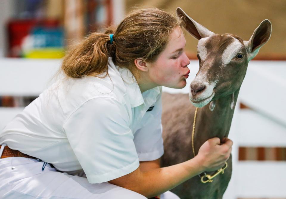 Anna Stoltman kisses her goat Taleah while waiting for judging at the 2023 Kentucky State Fair Thursday morning. The pair are from Lincoln County, Ky. Aug. 17, 2023