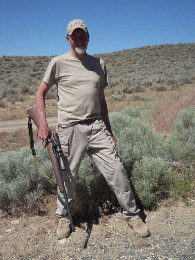 Chuck Mawhinney posing with a M40 rifle replica, the same type of rifle he used in Vietnam